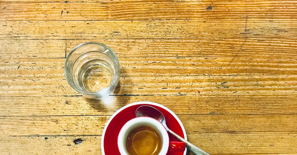 https://cdn.coffeeknowledgehub.com/media/2020/10/10/top_down_view_of_espresso_in_red_cup_and_saucer_with_glass_of_water_on_wooden_table.jpg?format=webp&q=80&w=1200&h=630&resize=entropy